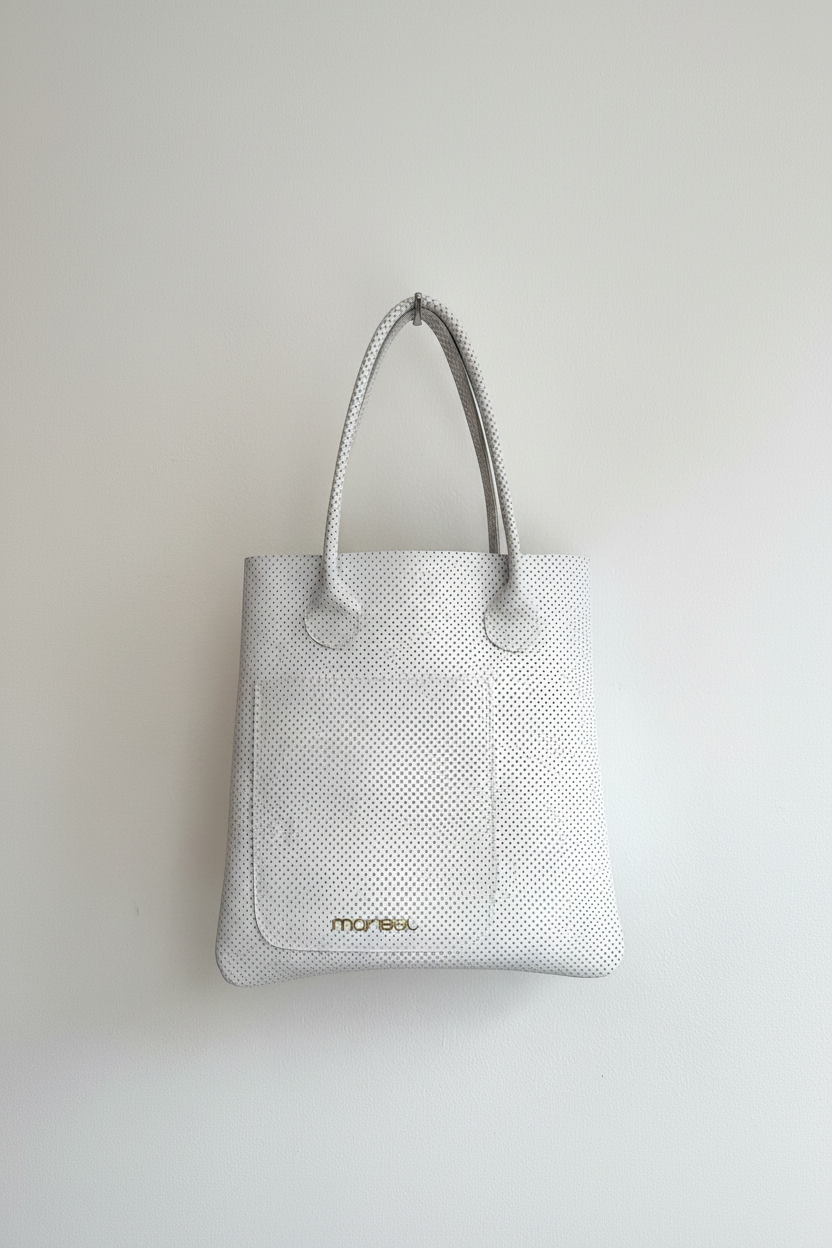 White textured tote bag with 'marisel' branding on a light gray background